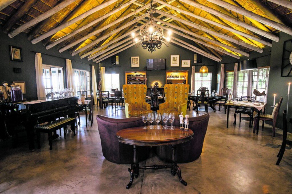Living room of a thatched safari lodge with a high beamed ceiling